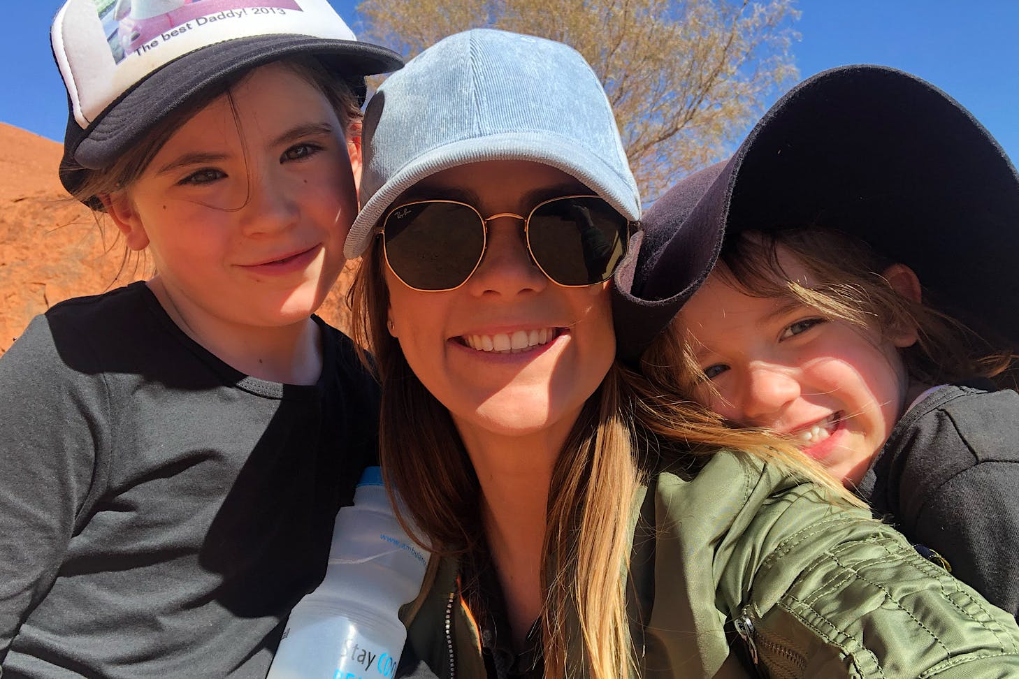 Bonnie and two little kids wear caps and look happy.